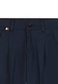 Granatowe spodnie z zapięciem na guziki z przodu, plisowanym fasonem oraz małym, wielokolorowym akcentem na pasie. Gładka tekstura.
