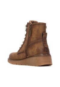 Botín de cuero marrón con un acabado texturizado, parte delantera con cordones, cremallera lateral y suela de goma acanalada para mayor tracción.