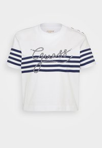 Bílý bavlněný tričko s námořnickými vodorovnými pruhy a vyšitým nápisem "Guess" v provazovém designu. Obsahuje knoflíkové detaily na rameni.