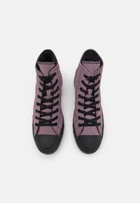 Lila höga sneakers med svart gummi tåskydd och snörning, med mjukt mockaskinn ovan och vadderad krage för komfort.