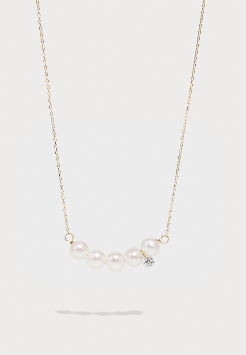 Colar de corrente de ouro com seis pérolas brancas e um único detalhe decorativo em cristal, exibindo uma textura suave e polida.