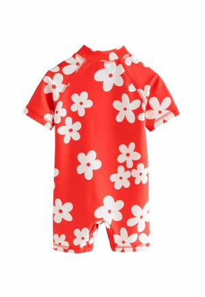 Combinaison de plongée courte à manches courtes rouge avec des motifs de fleurs blanches. Conçue en matériau extensible, avec des coutures renforcées et un col haut.