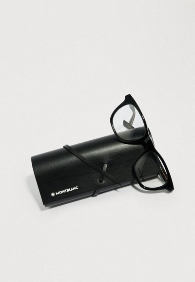 Černé brýle s obdélníkovými obroučkami ležící na válcovém černém pouzdře, upevněné černým řemínkem. Pouzdro je označeno bílým logem.