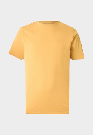 Camiseta lisa de manga corta con cuello redondo en amarillo mostaza sólido, exhibida sobre un fondo neutro gris claro.