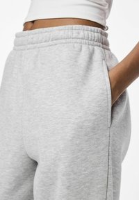 Light gray sweatpants made of soft cotton blend. Features elastic waistband and side pockets; smooth texture with subtle heather pattern.