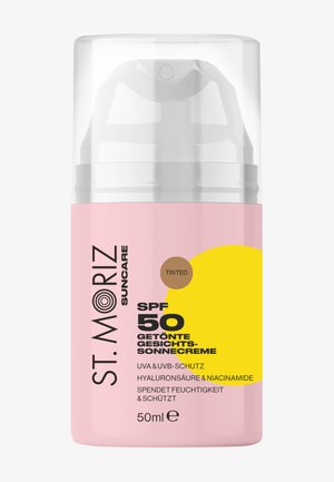 Crème solaire teintée pour le visage St. Moriz SPF 50 en flacon rose de 50 ml avec bouchon transparent, mettant en avant la protection UVA/UVB, l’acide hyaluronique et la niacinamide.