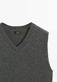Gray sleeveless cashmere sweater with a V-neck, featuring ribbed neckline and armholes, smooth texture, and no visible patterns or accents.