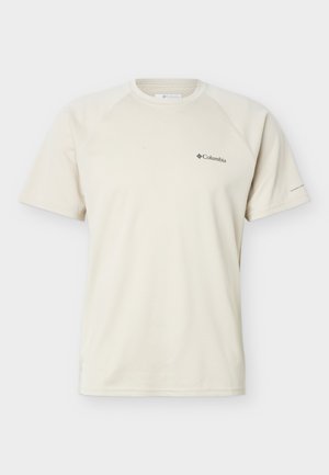 Μπεζ αθλητικό πουκάμισο Columbia με κοντά μανίκια και λαιμόκοψη, με μικρό λογότυπο στο στήθος και το κείμενο "Omni-Freeze" στο δεξί μανίκι.