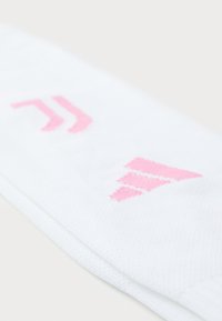 Weiße Socken mit strukturiertem Strick, die pinke grafische Akzente in einem Chevron-Muster aufweisen. Der Stoff wirkt weich und atmungsaktiv.