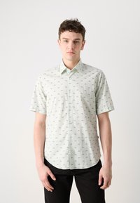 Camasa cu mânecă scurtă, cu nasturi, dintr-un material verde deschis, cu modele geometrice negre. Guler clasic, croială lejeră, margine curbată.