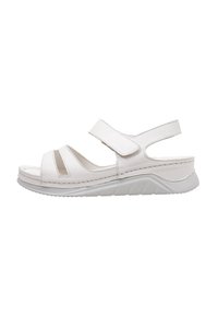 Sandalia blanca con correas de velcro anchas, diseño de punta abierta, plantilla moldeada y suela de goma texturizada. Presenta detalles recortados en los laterales.
