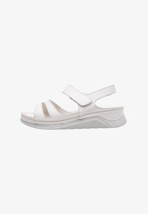 Sandale blanche avec de larges sangles Velcro, design à bout ouvert, semelle intérieure moulée et semelle en caoutchouc texturée. Comprend des découpes sur les côtés.