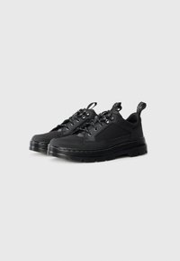 Black low-top sneakers with thick ridged soles, lace-up fronts, and fabric pull tabs on a plain white background.