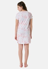 Bawełniana nocna suknia na krótki rękaw w białym kolorze z różowym wzorem tie-dye, do kolan, w luźnym kroju i zaokrąglonym dekolcie.