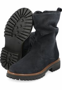 Mustat mokkanahkaiset nilkkurit, joissa on löysä muotoilu, kumipohja syvillä urilla, erottuva ommel yksityiskohtana pohjassa ja sivuvetoketju.