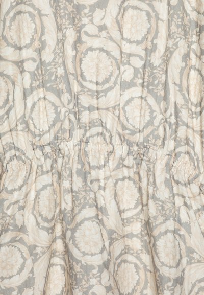 Tela con estampado floral en suaves tonos beige y gris, que presenta una cintura fruncida y una textura suave con detalles intrincados.