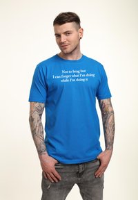 Camiseta de algodón azul de manga corta, con texto en blanco que dice: "No quiero presumir, pero puedo olvidarme de lo que estoy haciendo mientras lo hago."