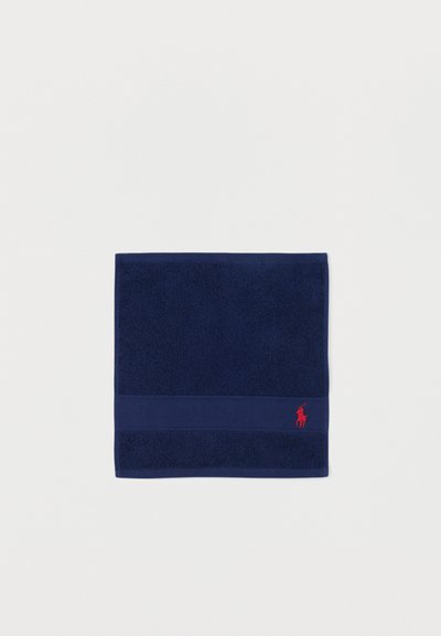 Marineblauwe handdoek met textuurrand aan de onderkant en een klein rood geborduurd logo van een polo-speler te paard.
