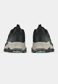 Chaussures de sport noires et grises avec une surface texturée, une semelle intermédiaire géométrique gris clair, une semelle extérieure noire et des accents verts au talon.