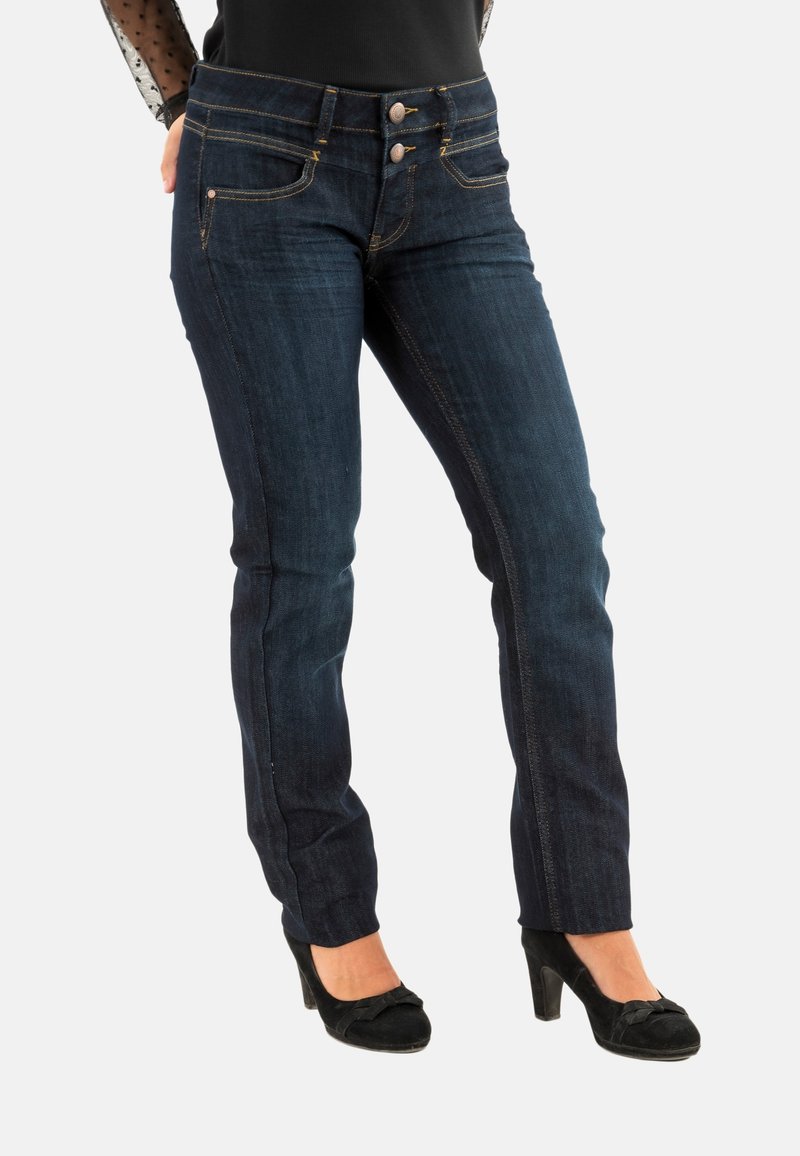 Jeans de mezclilla azul oscuro con un diseño ajustado, que presentan dos bolsillos delanteros y cierre de doble botón. Decorados con costuras doradas.