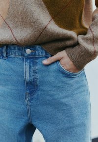 I jeans in denim blu presentano una vita a media altezza, un classico design a cinque tasche e cuciture a contrasto. Texture morbida, con una leggera finitura sbiadita.
