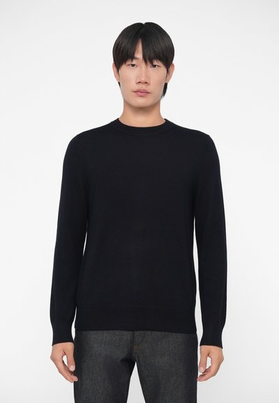 Pull marin à col rond fabriqué en maille douce. Il dispose de manches longues et d'une base ajustée, offrant un design simple et classique.