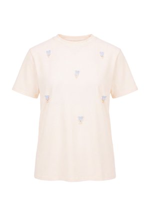 Kortærmet T-shirt i cremefarve med små blå hjerteapplikationer og perlelignende perler spredt over fronten. Ingen synlige logoer eller tekst.