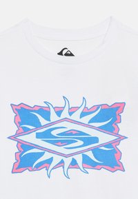 Λευκό T-shirt με πολύχρωμο γραφικό που απεικονίζει έναν μπλε και ροζ στυλιζαρισμένο ήλιο και διαμάντι, τοποθετημένο στο κέντρο κάτω από το γιακά.