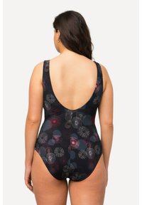 Maillot de bain noir à dos nu, arborant un motif floral multicolore. Le tissu est lisse et ajusté, avec de larges bretelles.