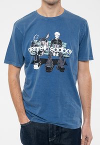 Blue cotton t-shirt featuring a graphic print of two characters sitting on a bench, with the text "genre: sadboy" in white. Short sleeves.