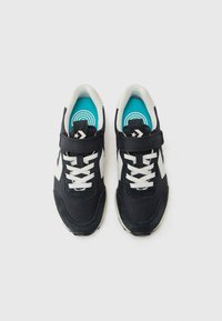 Sneakers met een zwarte stoffen bovenkant, witte accenten en blauwe binnenzolen. Voorzien van veters en een band voor een stevige pasvorm. Ronde teenvorm.