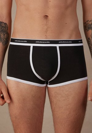 Boxer di cotone neri con fascia e bordatura bianca, dotati di un design a sacca sagomata e di un branding minimalista sulla fascia.