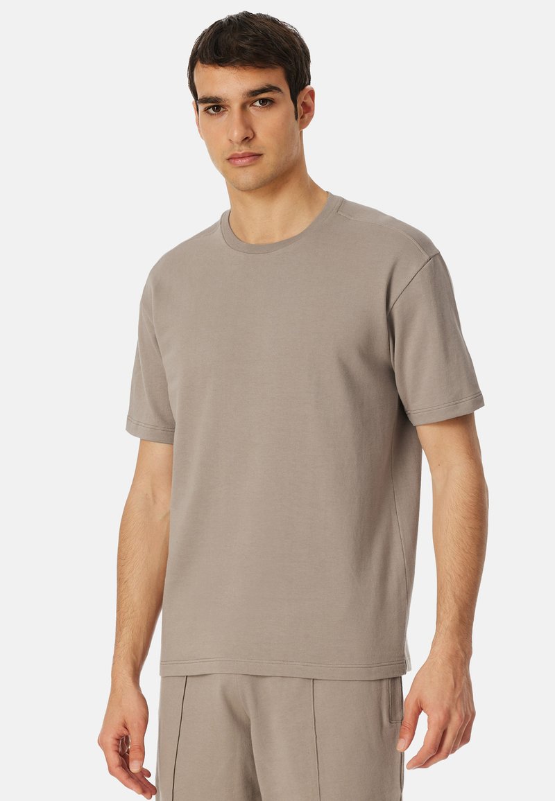 T-shirt grigio in cotone, maniche corte, collo girocollo, vestibilità rilassata, morbido al tatto, abbinato a pantaloni coordinati per un look omogeneo.
