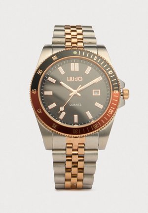 Ασημένιο και ροζ χρυσό μεταλλικό ρολόι χειρός με μαύρο καντράν, δείκτες ροζ χρυσού, τρία χέρια, παράθυρο ημερομηνίας και περιστρεφόμενη στεφάνη που δείχνει λεπτά.