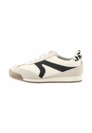 Beige og hvid sneaker med sort zigzagdetalje, ruskindsdetaljer, snørebånd og en brun tekstureret sål med et mønstret hælgreb.
