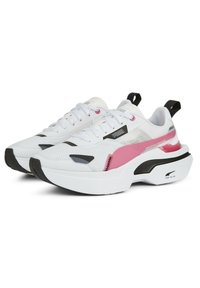 Baskets de sport blanches avec des matériaux en mesh et synthétiques. Présentent des accents roses, des détails noirs et une semelle blanche épaisse. Conception à bout arrondi.