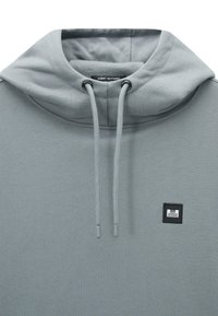 Felpa grigia con finitura testurizzata, dotata di cappuccio con cordino, patch con logo sul petto e polsini elasticizzati.