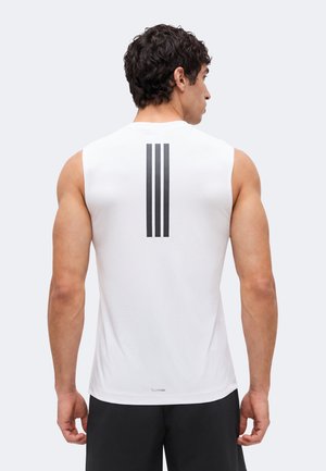 Mężczyzna zwrócony tyłem, ubrany w białą, bezrękawnikową sportową koszulkę z trzema pionowymi czarnymi paskami na górnej części pleców oraz czarne spodenki.