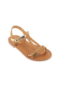 Tan leren sandaal met gevlochten banden, gouden accenten en een platte zool. Beschikt over een verstelbare enkelgesp voor pasvorm en comfort.