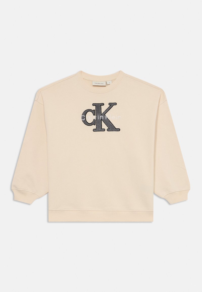 Beige collegepaita, jossa on pyöreä pääntie ja pitkät hihat. Etupuolella musta brodeerattu "CK" -logo ja "calvin klein" -teksti.