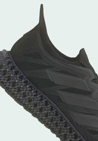 Chaussure de sport noire avec une semelle texturée imprimée en 3D et trois bandes diagonales sur le côté, avec une tige en maille type chaussette.