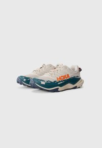 Lichte hardloopschoenen met een crèmekleurige bovenkant, teal accenten en een gedurfde oranje logo. Heeft een gestructureerd mesh en een duurzame rubberen zool.