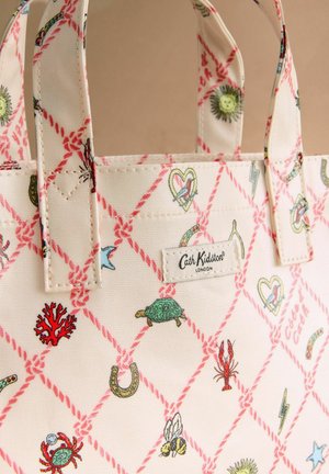 Valkoinen kangaskassi, jossa vaaleanpunaiset köysikuviot timantinmuotoisina ja pieniä värikkäitä eläin- ja symbolikuvituksia; etupuolella Cath Kidston Londonin logolappu.