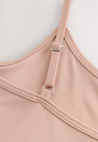 Nahaufnahme eines verstellbaren hellrosa Stoffriemens an einem Kleidungsstück mit silbernem Metallschieber und Nahtdetails.