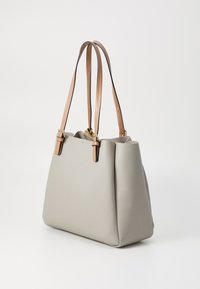 Pelēka ādas somiņa ar divām gaiši brūnām siksnām un zelta aksesuāriem, piedāvājot strukturētu dizainu un gludu tekstūru.