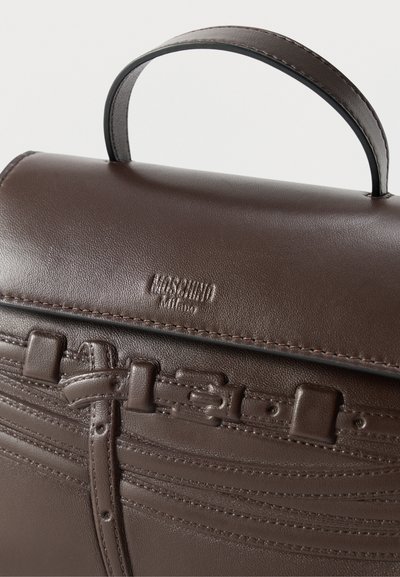 Σκούρα καφέ δερμάτινη τσάντα χειρός με επάνω χειρολαβή, ραμμένες λεπτομέρειες και μια μικρή πόρπη στην εμπρόσθια φλάντζα.