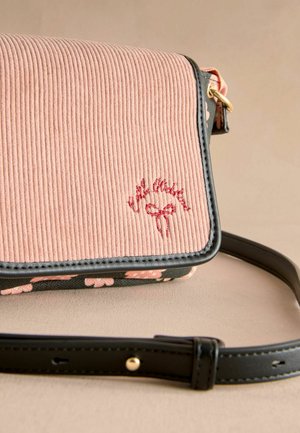 Rózsaszín corduroy crossbody táska fekete bőr részletekkel, virágmintával az alján és hímzett díszítéssel. Állítható pánt is jár hozzá.