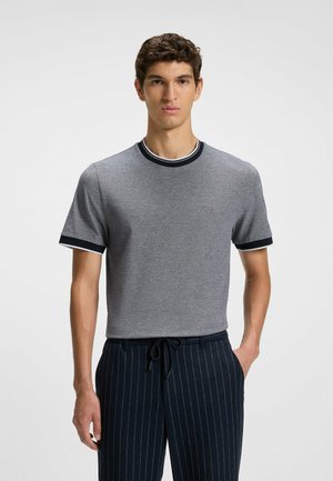 Graues Kurzarm-T-Shirt mit einem gerippten, marineblauen Kragen und Bündchen. Mit einer subtilen Textur und gesticktem Logo auf der Brust.