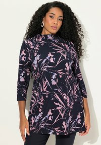 Tunika navy con motivo floreale in rosa e viola. Presenta un colletto alto e maniche a tre quarti, realizzata in tessuto morbido e elasticizzato.
