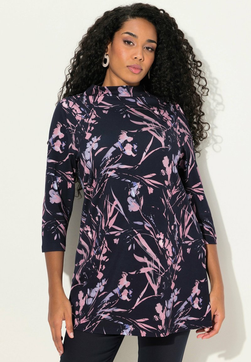 Tunika navy con motivo floreale in rosa e viola. Presenta un colletto alto e maniche a tre quarti, realizzata in tessuto morbido e elasticizzato.